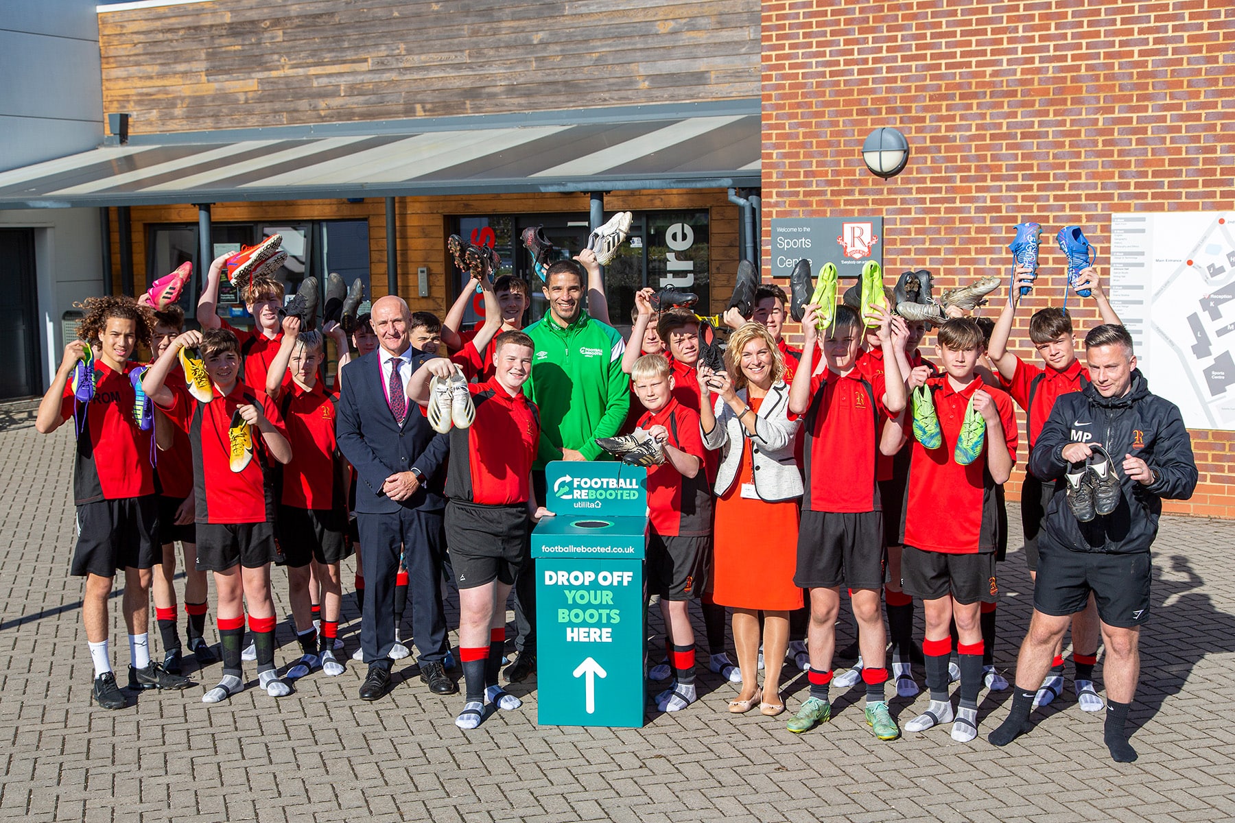 David James at a school with young football players featuring the Football Rebooted donation bin