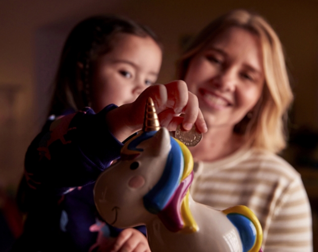 Children putting money into a piggy bank